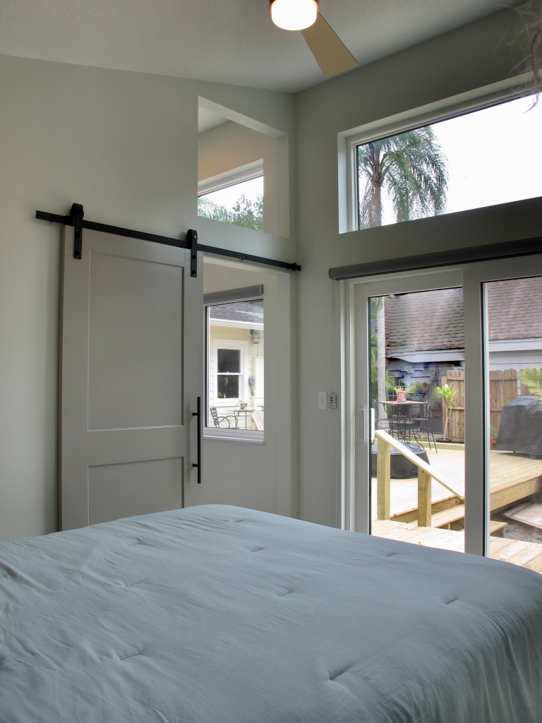 Bedroom view with pocket door, sliding glass door, and clerestory openings or windows above
