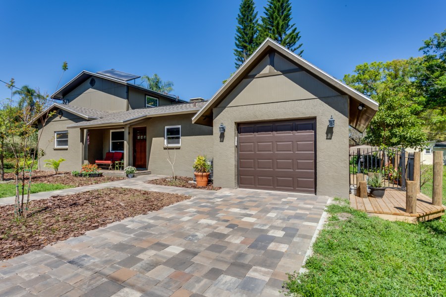 1-story addition with front porch and garage, with 2-story main home in background