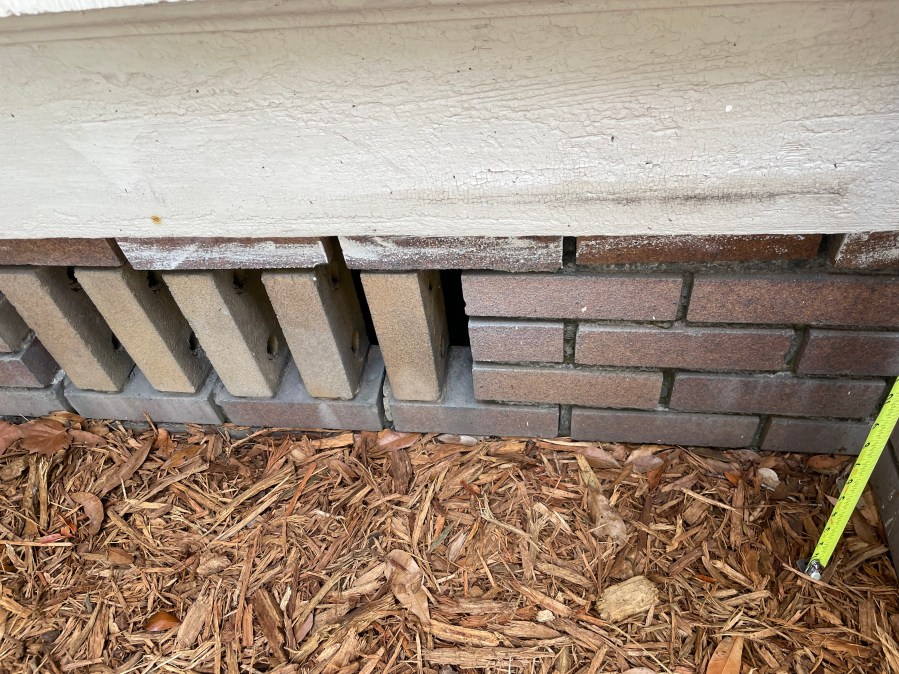 Brick foundation wall showing ventilation from vertical bricks spaced apart for airflow