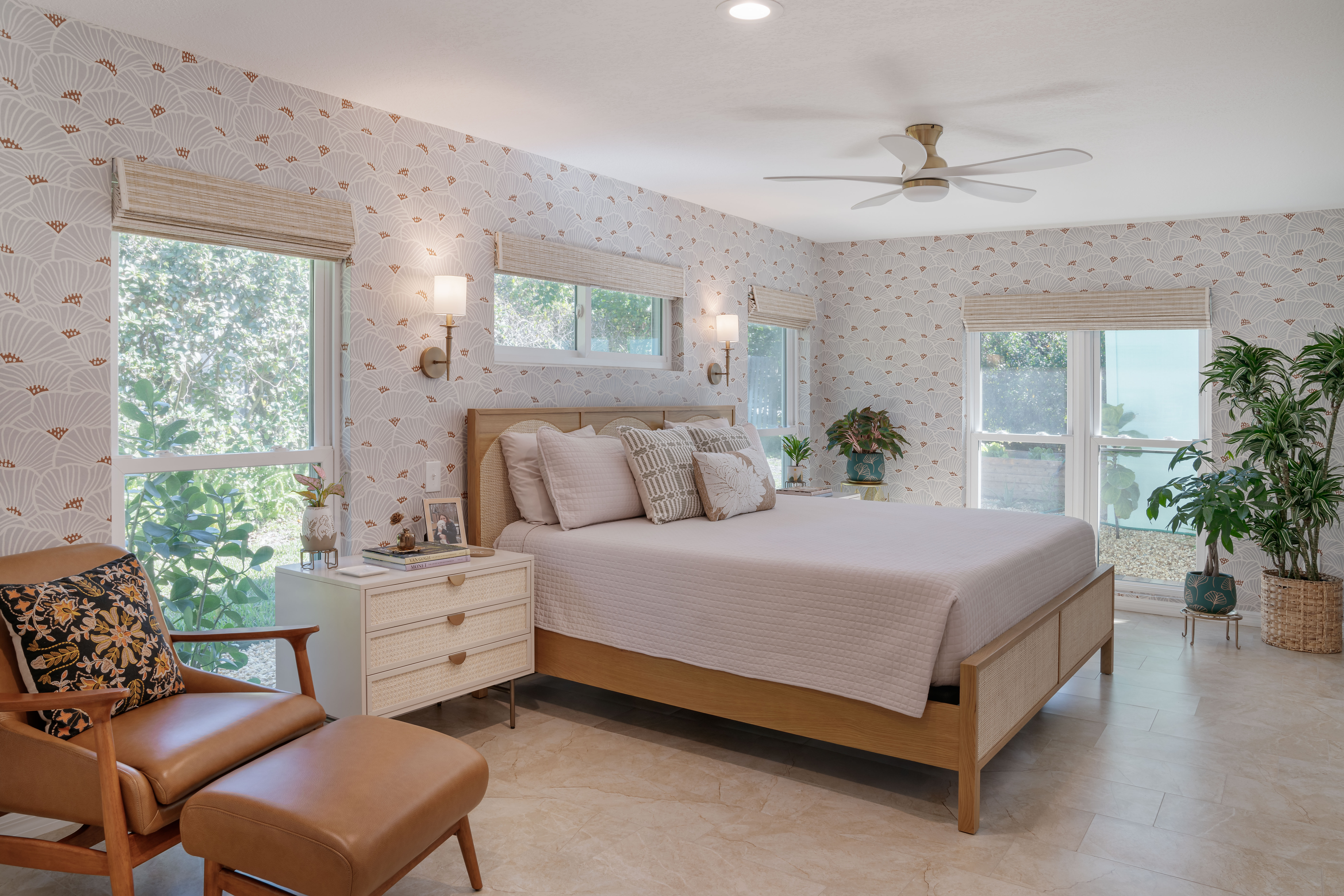 Large bedroom with bed at center with large windows surrounding it