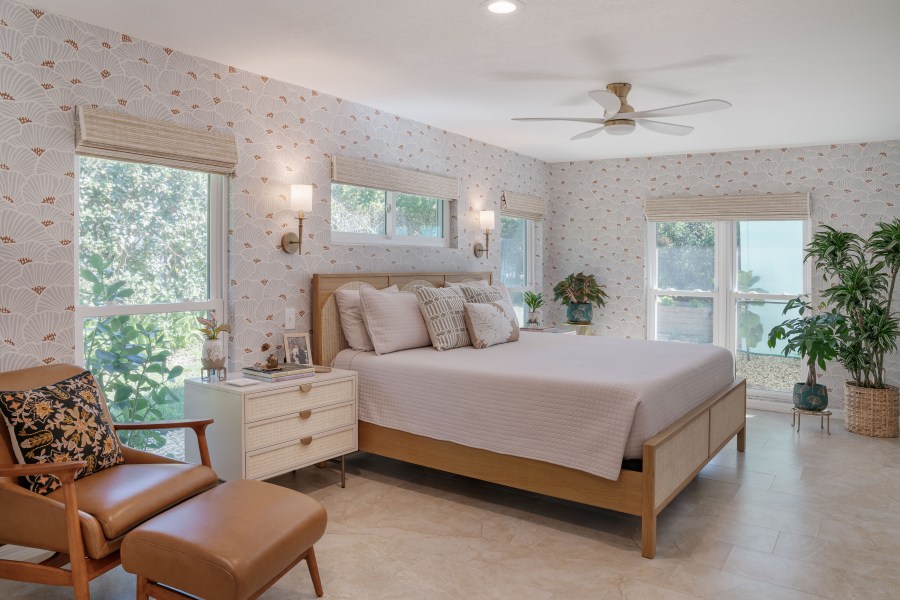 Large bedroom with bed at center with large windows surrounding it