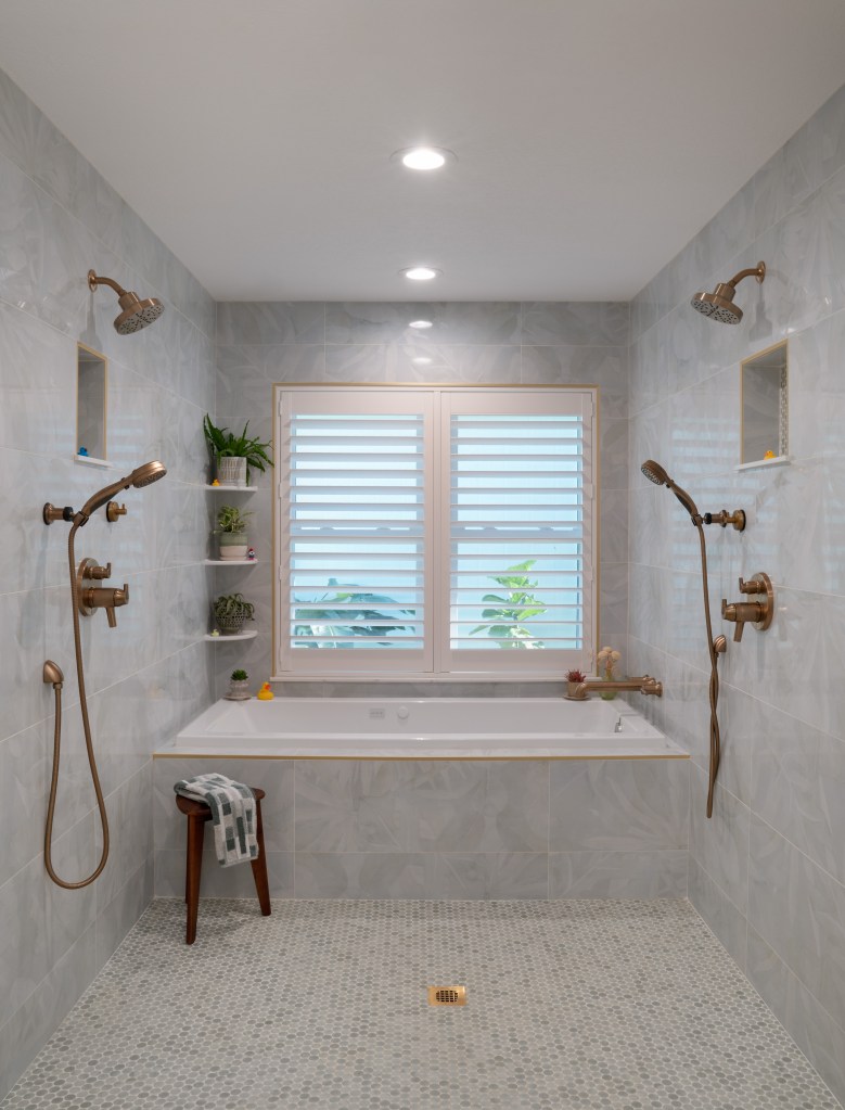 Spa-like wet room design with large walk-through shower and deep soaking tub under the window