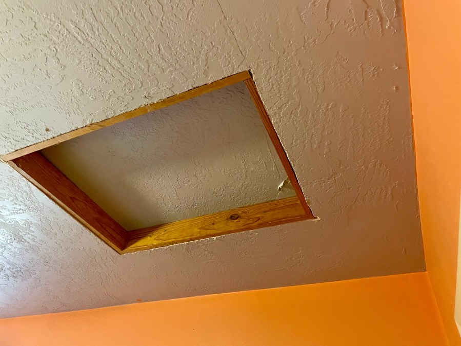 Closed attic access panel in a 1983 Florida home ceiling